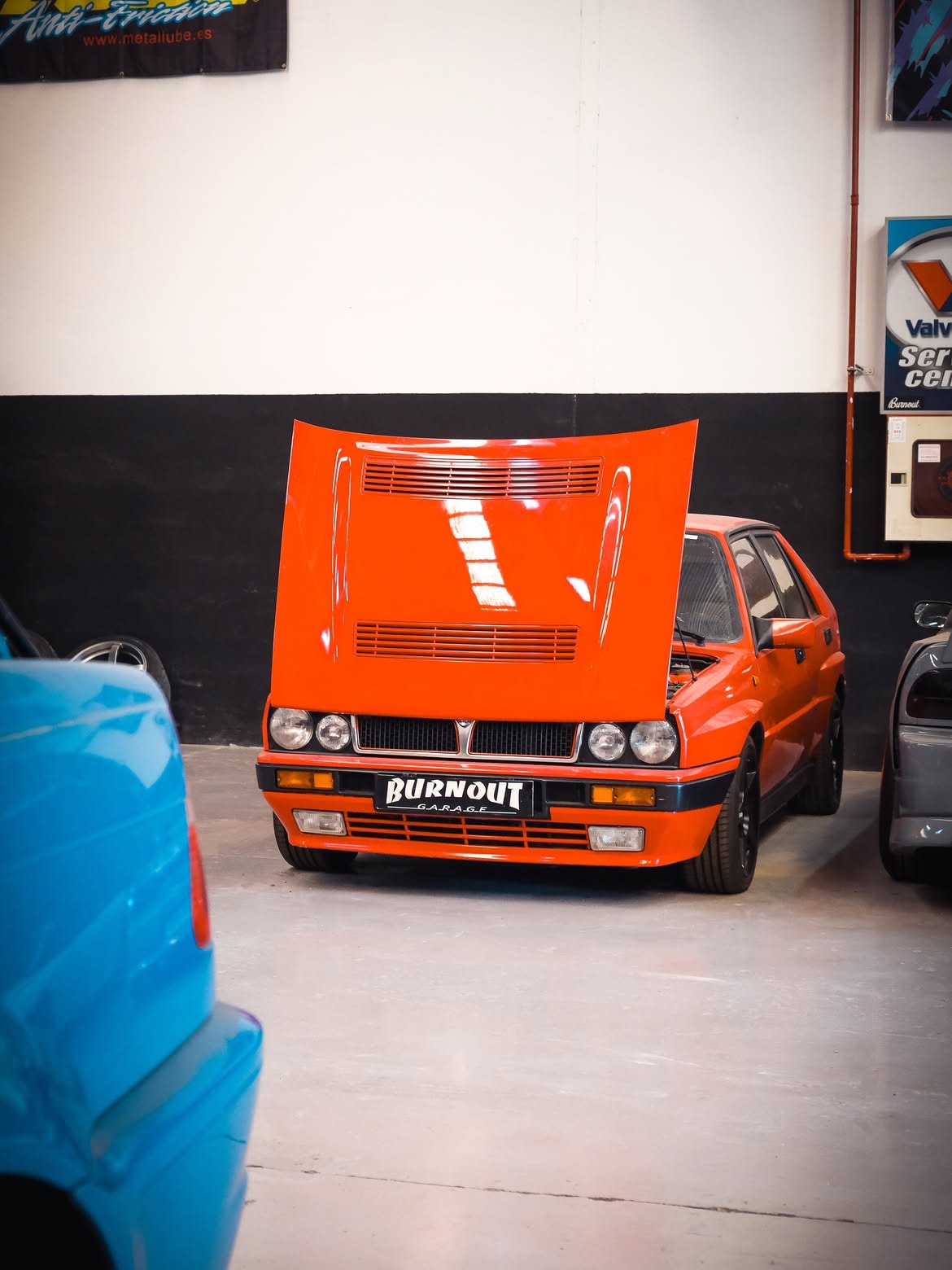 Coche clásico naranja en el taller Burnout Garage